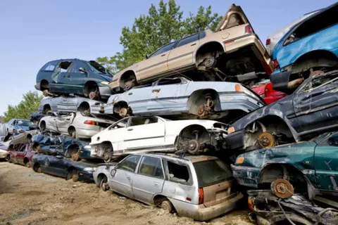 A tow truck picking up an old, damaged car from a driveway, symbolizing the hassle-free removal service provided by Car Wreckers Melbourne